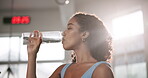 Woman, drinking water and health in gym with fitness for exercise break, thirsty and hydration for body wellness. Athlete, person and rest with liquid for fatigue from training and physical activity