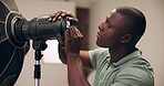 Photography, man and lighting setup in studio for production, preparation and equipment for photoshoot. Photographer, black person and setting camera for flashlight, spotlight and behind the scenes