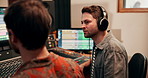 Studio, teamwork or male producer with headphones for listening, hearing or track consistency of song. Creative people, sound engineer and music audio mixer for volume level, frequency and recording
