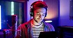Man, musician and headphones with tablet in studio for music production, media streaming and search in neon. Artist, singer and entertainment industry with digital app for song lyrics and learning