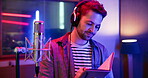 Man, singer and recording studio with notebook for writing lyrics, notes and neon color. Artist, creative and serious as musician with headphones for music or song and album production with talent
