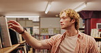 Search, student and man in library looking for textbook with education, knowledge or learning. University, information and male learner at bookshelf for studying, project research or scholarship