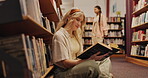 Student, woman and reading on floor in library for literature research or studying for knowledge. Gen z girl, novel and search for academic information in book for scholarship, education and learning