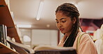 Student, woman or reading a book in library for studying, literature research and learning for knowledge. Happy gen z, novel and searching for academic information for scholarship, education and exam