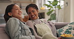 Women, friends and watching tv with laugh, comedy and potato chips on sofa with streaming for movie. Girl, people and relax with snack, talk and comic film with subscription on television in house