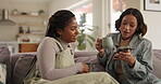 Friends, smartphone and coffee cup on sofa for social media post, bonding and internet news in home. Women, mobile tech and conversation on couch for online banking, communication and networking
