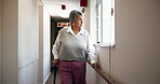 Thinking, senior woman and walking stick in nursing home with depression, retirement or disability by window. Sad, anxiety or elderly female person in corridor with unhappy past memory, grief or pain