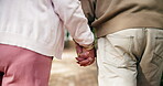 Senior couple, holding hands and walk in garden for love, retirement and date together. Smile, elderly man and woman in backyard of nursing home for support in nature for anniversary and wellness