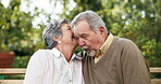 Senior couple, whisper and together in garden for love, retirement and connection for date. Secret, elderly man and woman in backyard of nursing home for gossip in nature for relationship or wellness