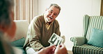 Love, senior couple and man with photograph on a sofa for memory, remember and nostalgic conversation with woman at home together. Photography, history and old people in living room with photo album