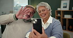 Senior couple, video call and wave with phone in home for talking, communication or laughing. Man, woman and hello in virtual chat on smartphone for funny conversation, retirement or greeting online