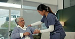 Senior woman, physiotherapist and holding hands in wheelchair for shoulder pain, help and consultation in clinic. Nurse, talk and elderly person with disability with recovery, steps or rehabilitation