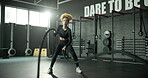 Woman, battle rope and wellness in gym, cardio exercise and muscle building for fitness. Intense routine, moving and body fitness with power or strength training, weight equipment and bicep challenge