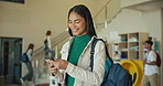 University, education and woman with phone on campus for studying, class and learning. Scholarship, happy and female student in hallway on smartphone for social media, internet and website at school