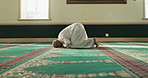 Muslim man, worship or bow on carpet in Mosque for peace, gratitude or support to Allah in holy temple. Dua, Islamic and spiritual male person praying to ask God on Ramadan Kareem in Saudi Arabia