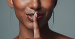 African woman, lips and finger with hush, studio and silence for mystery announcement. Model, skincare secret and gossip with rumor, whisper and gesture for news with privacy on gray background