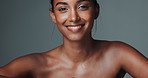 Portrait, skincare and beauty of happy Indian woman in studio isolated on gray background. Face, smile and young model in makeup for facial cosmetics, dermatology or laughing for healthy glow at spa