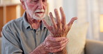 Senior man, pain and touch hand for injury with arthritis problem, inflammation and healthcare in nursing home. Elderly person, wrist massage and hurt for osteoporosis, fibromyalgia or muscle cramps