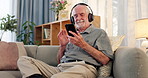 Senior man, dancing and headphones for music with smile, radio and phone for audio playlist on couch. Elderly person, hearing sound track and dance for favorite song, streaming podcast and happiness