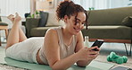 Woman, relax and phone for yoga break in home, texting and app for conversation on floor. Female person, self care and rest from exercise or pilates challenge, social media and scroll on internet