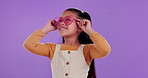 Sunglasses, happy and child in studio mockup ready for summer vacation, adventure or holiday. Smile, cute and girl kid with heart shape accessory for fun tropical weekend trip by purple background.