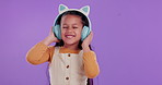 Happy girl, child and listening with headphones to music in studio for audio or streaming on a purple background. Young female person or little kid with smile for sound, playlist or album on mockup