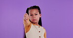 Studio, face and hands of kid with thumbs down for bad review, vote and rejection on purple background. Little girl, frown and gesture in portrait with emoji for feedback, decision or negative rating