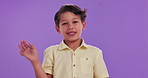 Happy boy, child and wave with greeting in studio for introduction, hello or bye on a purple background. Portrait of male person or friendly little kid with smile for presentation, signal or gesture