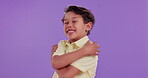 Happy, kid and care with hug in studio for self love, acceptance and kindness on purple background. Adorable, little boy and smile with gesture of embrace for development, growth and childhood