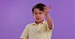 Finger, no and face of child in studio with hand gesture for rejection, refuse and stop on purple background. Emoji, body language and portrait of boy with sign for self defense, warning and protest