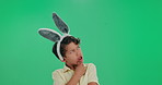 Thinking, excited and child in studio with bunny ears for ideas, playful character and easter celebration, Fun, face and boy in rabbit costume for inspiration, solution or kid on green background