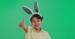 Happy boy, child and agreement with thumbs up on green screen, studio or background. Portrait of little kid with bunny ears, like emoji or yes sign for winning, review or feedback on mockup space