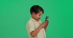 Happy, green screen and child in studio with phone for online games, internet and mobile app. Youth, playing and young boy on smartphone for connection, communication and chat on chromakey background