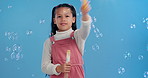 Fun, wand and child in studio with bubbles for magic, playing and games for growth, development or celebration. Girl, soap and liquid solution for playful entertainment, curiosity and blue background