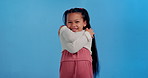 Hug, face and child in studio with self love, smile or identity development for happy kid. Care, embrace and portrait of girl with positive attitude, growth and confident mindset on blue background