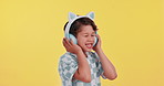 Happy, music and child with headphones in studio for streaming subscription, audio and radio. Relax, youth and young boy dancing and listening to playlist, song and track on yellow background