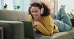 Video call, online and woman with laptop, couch and wave for contact, happy and relax for communication. Home, smile and girl with headphones, digital and chat with computer and rest in living room