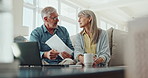 Senior couple, documents and discussion with laptop for financial expenses or bills at home. Elderly man and woman discussing paperwork with laptop on sofa for finance, retirement or pension fund