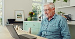 Laptop, happy and mature man in kitchen with pride and satisfaction for winning online bet. Excited, celebration and senior male person read good news email on computer for investment profit at home.