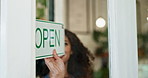 Open, cafe and small business of entrepreneur, notice and closeup of door, hand and startup of retail. Morning, person and owner of coffee shop, industry and barista in hospitality, loan and entrance