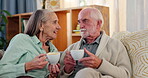 Senior couple, coffee and relax on sofa with conversation for bonding, relationship and comfortable with affection. Man, woman and beverage on couch in home, communication together and commitment.