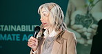 Presentation, senior woman and microphone at workshop for environment care, climate change or resources. Female speaker, representative or tech at convention for information, sustainability or growth