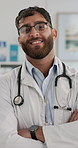 Hospital, healthcare and face of doctor with crossed arms for medical care, insurance and consultation. Professional, portrait and man with stethoscope for cardiology, pulmonary service and wellness