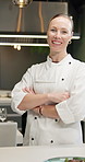 Portrait, chef and happy woman with arms crossed at restaurant in kitchen for career, pride and catering. Face, confidence and cooking professional in small business with culinary worker in Australia