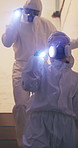 Investigation, team and people in ppe for hazard at drug lab for illegal pharmaceutical. Torch, inspection and law enforcement in medical suit at crime scene for heroin, opioid and cocaine production