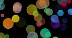 Multicolor, bokeh and abstract or bubbles by black background, screensaver and wallpaper. Particles, glitter or spotlight by backdrop for aesthetic, glow and movement or effects for creativity or art