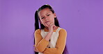 Confused, kid and hand with thinking in studio for question, wonder and doubt in decision. Little girl, face and gesture with contemplating for planning, idea and solution on purple background