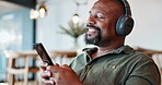 Relax, black man and headphones with music on phone for streaming video, podcast and networking on social media. African, male person and mobile for listening, playlist audio and dancing at home