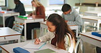 Teenager, girl and writing in quiz with learning, thinking and ideas in classroom, scholarship or education. Female person, student and remember in high school,  development with confident in academy