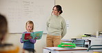 Teacher, student or kid for presentation in classroom, reading and kindergarten education. Woman, child and show to talk in class to speak to audience for assessment, speech or development at school